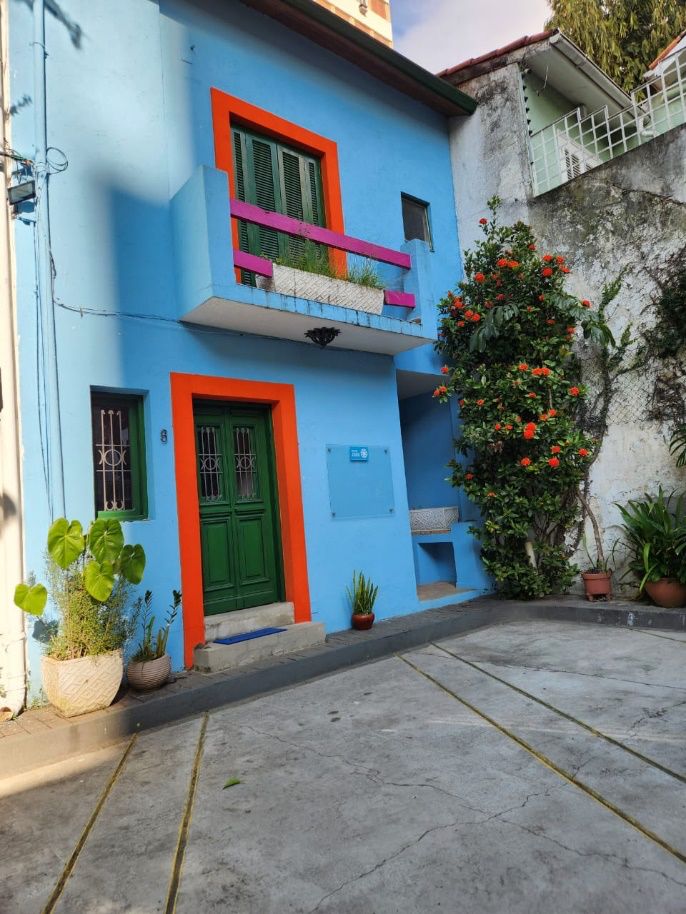 Entrada colorida da sede do Instituto Realiza.vc com paredes azuis e detalhes laranja