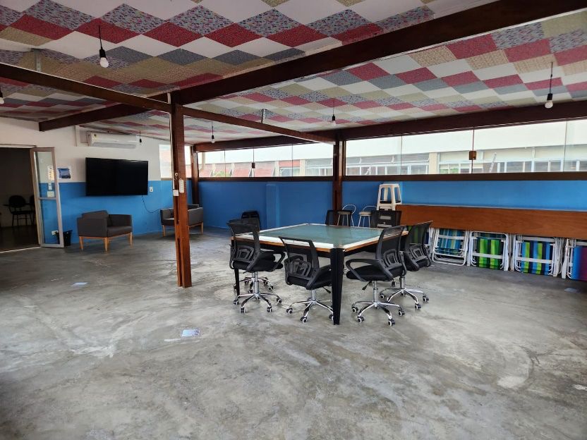 Terraço com mesa de reunião, cadeiras e teto com design de retalhos coloridos